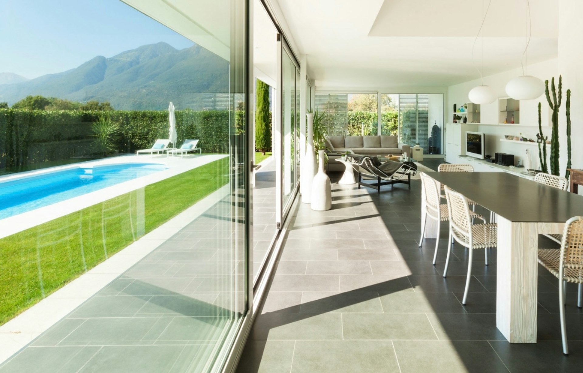 Sala y comedor con vista a un jardin con alberca